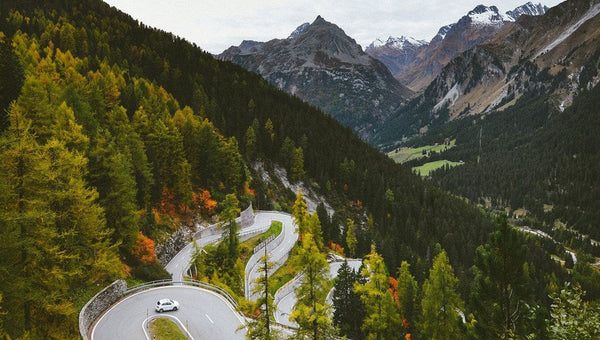Car on windy road amid forest stocked with car emergency kit