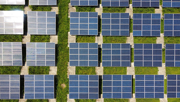 large field filled with solar panels producing solar energy