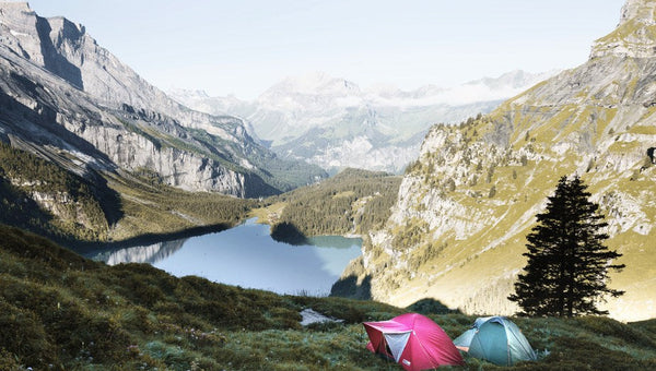 two tents sit on mountain with wild camping essentials