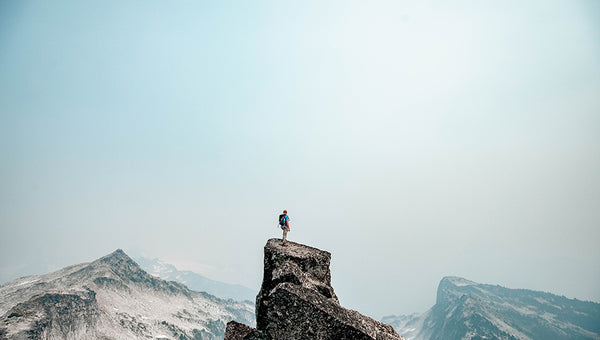 hiker standing on top of a mountain using phone powered by portable power station uk